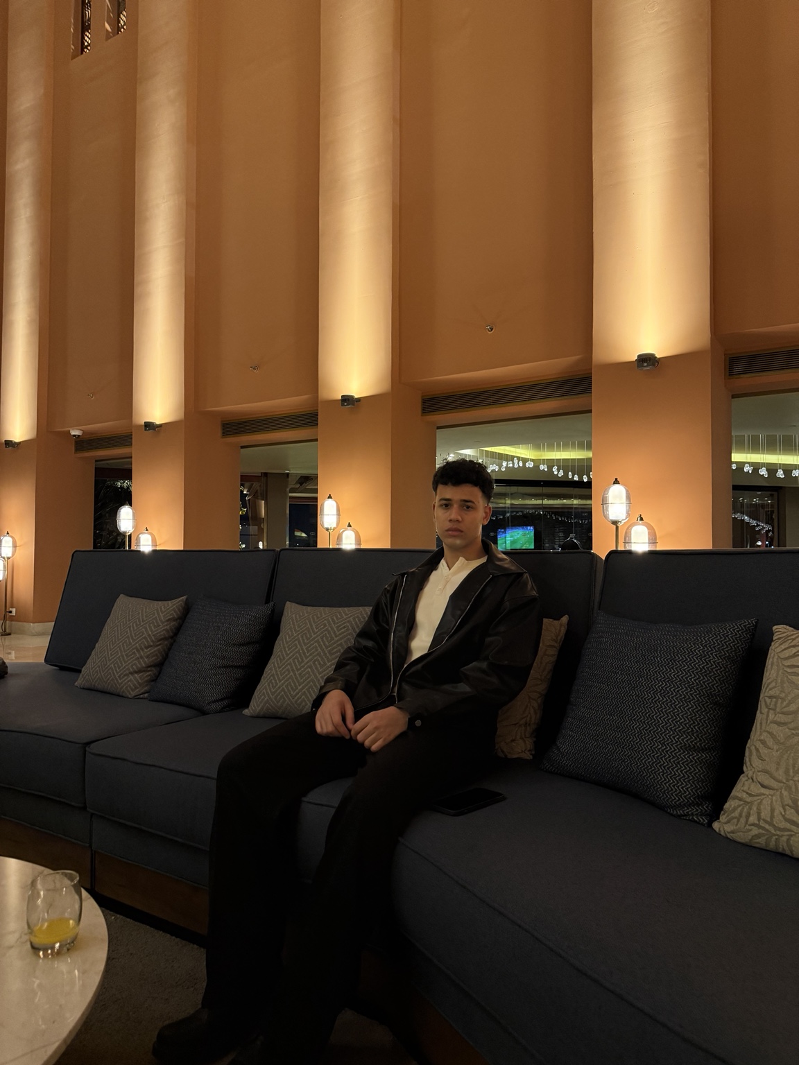 Abdulrahman Amr seated in a warmly lit lounge
